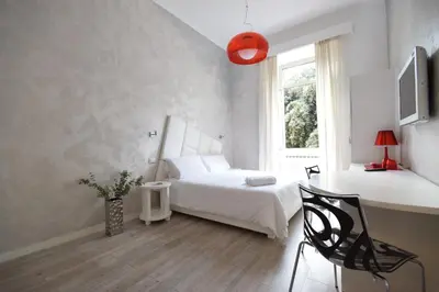 a bedroom with a bed and a desk and a window at Habana's Design in Rome