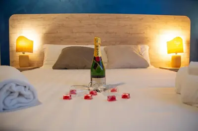 a bottle of wine and candles on a bed at Romerooms in Rome