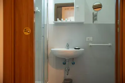 a bathroom with a sink and a glass shower at Romerooms in Rome