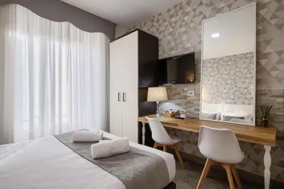 a bedroom with a bed and a desk and a mirror at Domus Pietro Inn in Rome