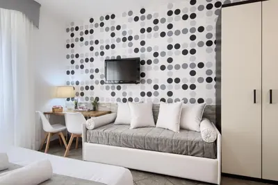 a bedroom with a couch and a tv on a wall at Domus Pietro Inn in Rome