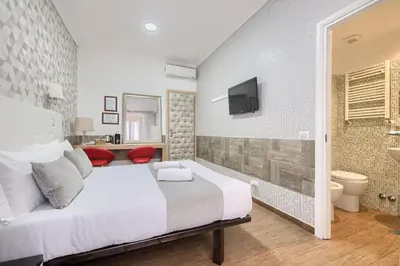 a bedroom with a white bed and a bathroom at Domus Pietro Inn in Rome