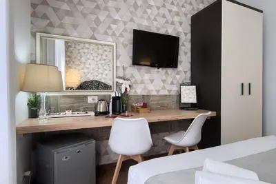 a bedroom with a desk and a mirror at Domus Pietro Inn in Rome