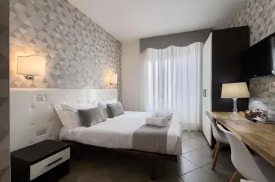 a bedroom with a bed and a desk in it at Domus Pietro Inn in Rome