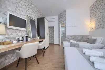 a living room with two beds and a dining room at Domus Pietro Inn in Rome