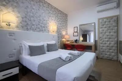 a bedroom with a large white bed and a mirror at Domus Pietro Inn in Rome