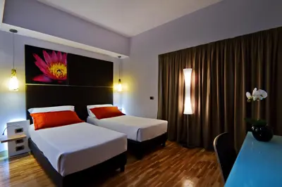 a hotel room with two beds and a table at Hotel Gravina San Pietro in Rome