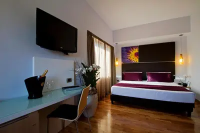 a bedroom with a bed and a desk and a television at Hotel Gravina San Pietro in Rome