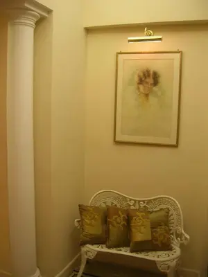 a white bench in a room with a picture on the wall at Maison de Marta in Rome
