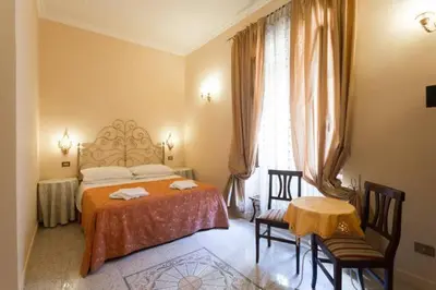 a bedroom with a bed and a table and chairs at Maison de Marta in Rome