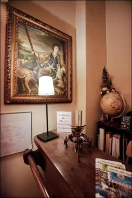 a lamp on a table with a painting on the wall at Maison de Marta in Rome