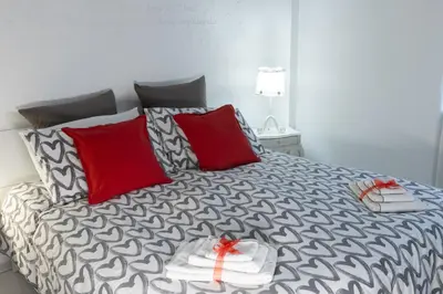 a bedroom with a bed with red pillows at Baglioni Vatican House in Rome