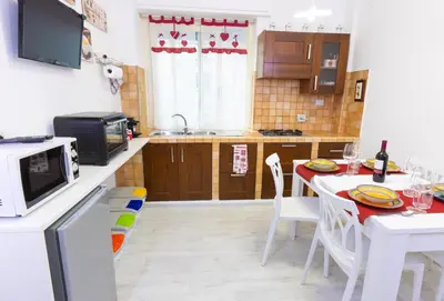 a kitchen with a table with chairs and a microwave at Baglioni Vatican House in Rome