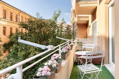 a balcony with chairs and a table and flowers at Goldie in Rome