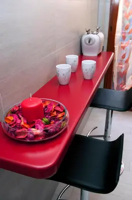 a red table with a candle and cups on it at La Casetta del Vaticano in Rome
