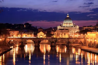 a bridge over a river in front of a building at La Casetta del Vaticano in Rome