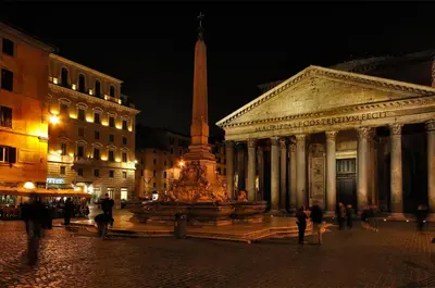a large fountain in front of a building at night at La Casetta del Vaticano in Rome