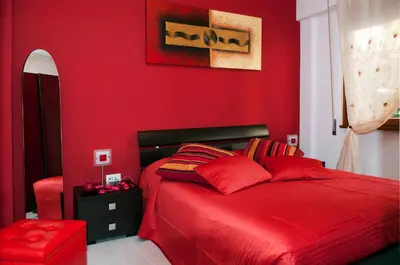 a red bedroom with a bed and a red wall at La Casetta del Vaticano in Rome