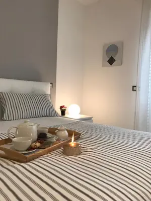 a tray of food and a candle on a bed at Sweet Home Roma in Rome