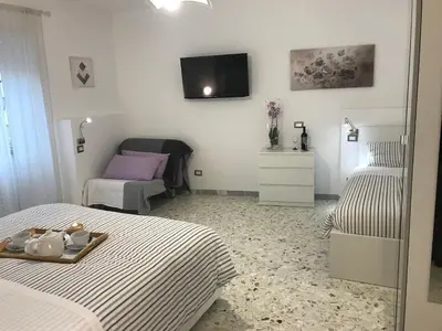 a bedroom with two beds and a tv on the wall at Sweet Home Roma in Rome
