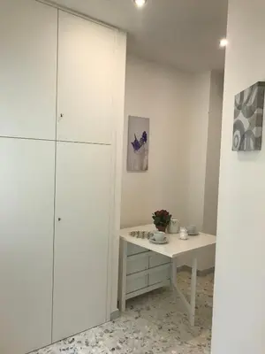 a white room with a table and a cabinet at Sweet Home Roma in Rome