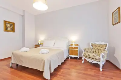 a bedroom with a white bed and a chair at Liberty Trastevere B&B in Rome