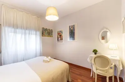 a bedroom with a bed and a table and chair at Liberty Trastevere B&B in Rome