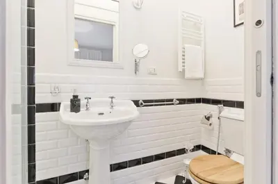 a white bathroom with a sink and a toilet at Liberty Trastevere B&B in Rome