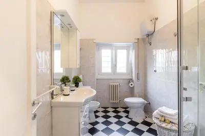 a white bathroom with a sink and a toilet at Liberty Trastevere B&B in Rome