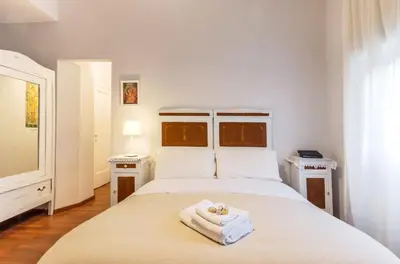 a bedroom with a white bed with towels on it at Liberty Trastevere B&B in Rome
