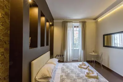 a bedroom with a bed with two pairs of shoes on it at Stazione San Pietro 20 Apartment in Rome