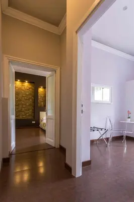 an empty living room with a hallway with a brick wall at Stazione San Pietro 20 Apartment in Rome