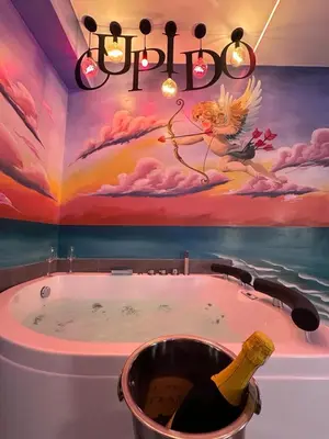 a bathroom with a tub with a bottle of champagne at Cleopatra in Rome