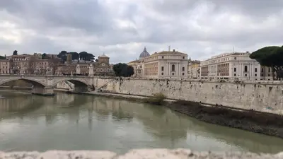 a bridge over a river in a city with buildings at la casetta dei sogni in Rome