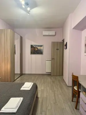 a room with a bed and a table and a door at la casetta dei sogni in Rome