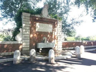 a monument in a brick wall with a plaque at La Riva Sinistra in Rome