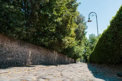 a stone path next to a wall with a street light at Domus Quiritum Villa in Rome