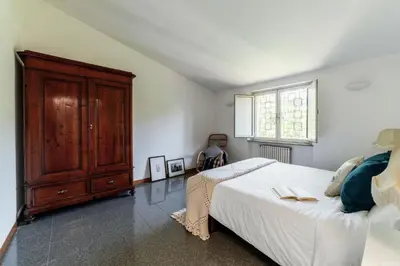 a bedroom with a large bed and a wooden cabinet at Domus Quiritum Villa in Rome
