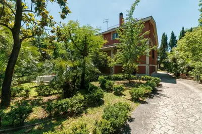an exterior view of a house with trees and a driveway at Domus Quiritum Villa in Rome