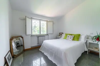 a white bedroom with a bed and a mirror at Domus Quiritum Villa in Rome