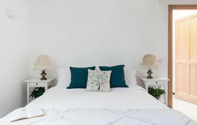 a bedroom with a white bed with blue pillows at Domus Quiritum Villa in Rome