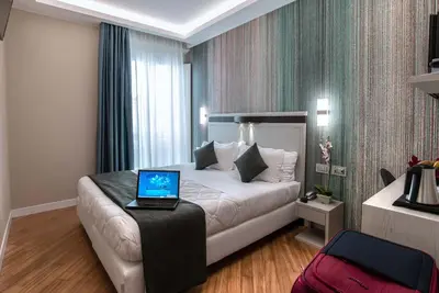 a hotel room with a bed with a laptop on a table at Hotel Memphis in Rome