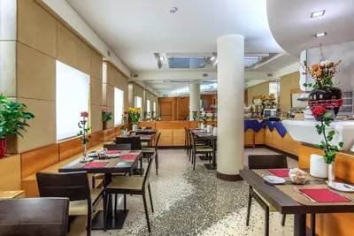 a restaurant with wooden tables and chairs and flowers at Hotel Memphis in Rome