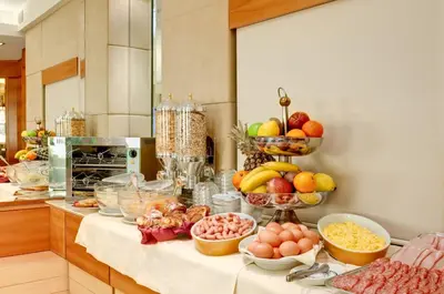 a kitchen with bowls of fruits and vegetables on a table at Hotel Memphis in Rome