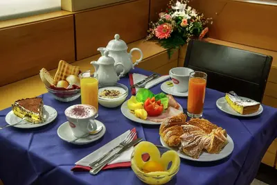 a table with breakfast foods and drinks on it at Hotel Memphis in Rome