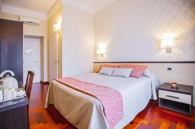 a hotel room with a large bed and a table at Domus Palatina in Rome