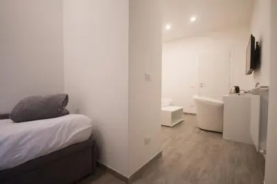 a white room with a bed and a bathroom at Trastevere Sweet Dream in Rome