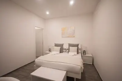 a white bedroom with a bed and a painting on the wall at Trastevere Sweet Dream in Rome