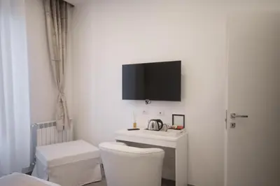 a bathroom with a toilet and a tv on the wall at Trastevere Sweet Dream in Rome