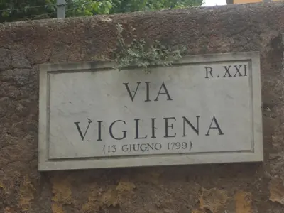 a sign on the side of a stone wall at My Rhome Prati in Rome